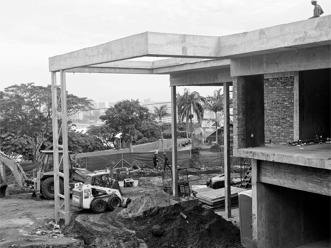 Concrete frame and construction activity viewed through structural openings