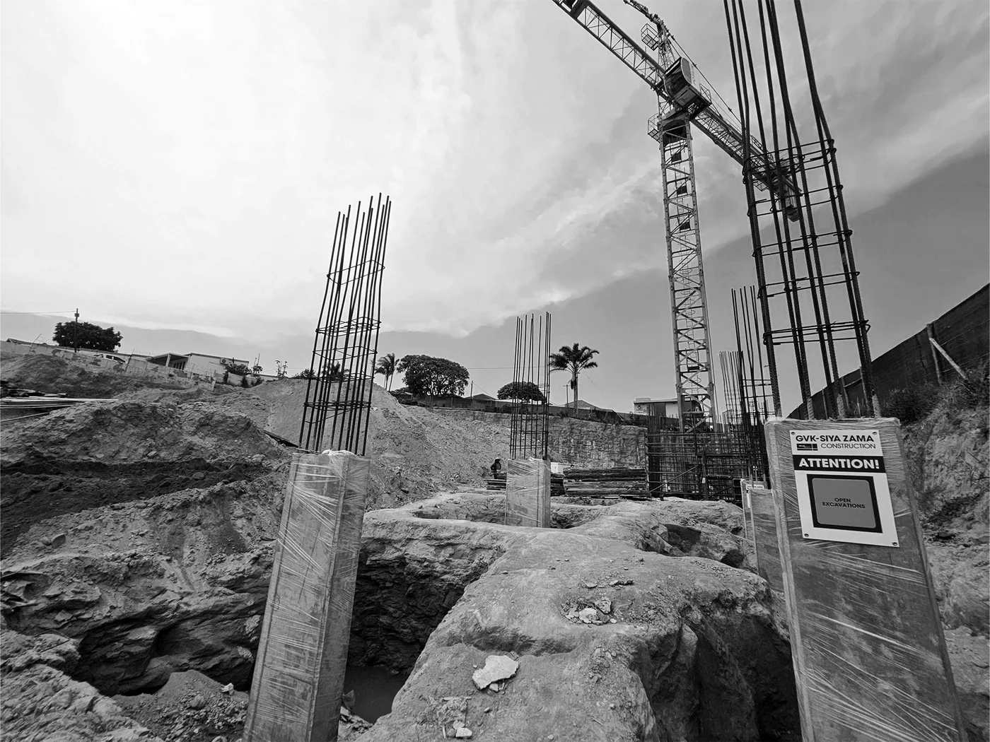 Concrete columns and reinforcement rising from a deep excavation