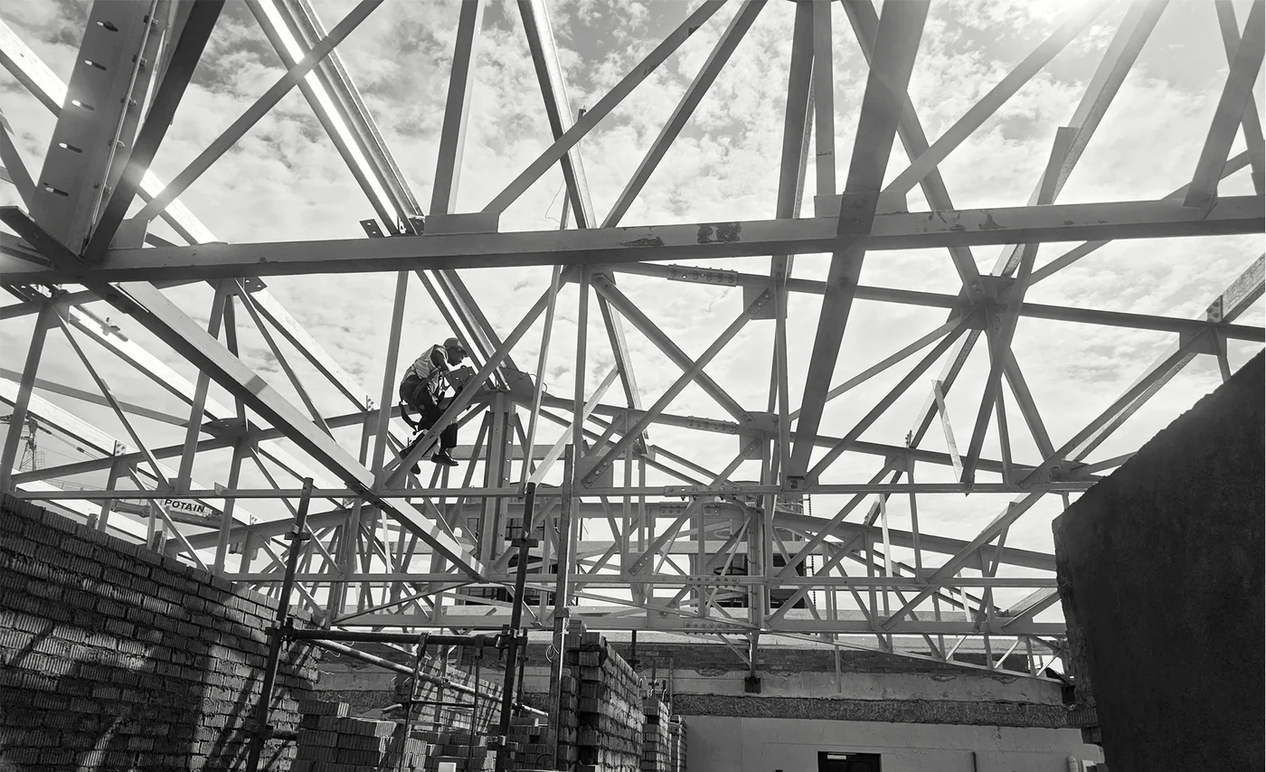Roof trusses spanning over an existing masonry structure